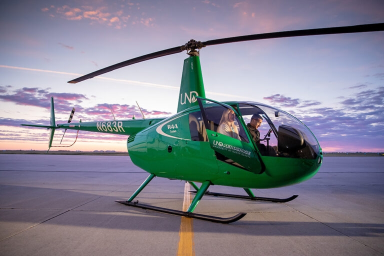 Two people sit in UND helicopter