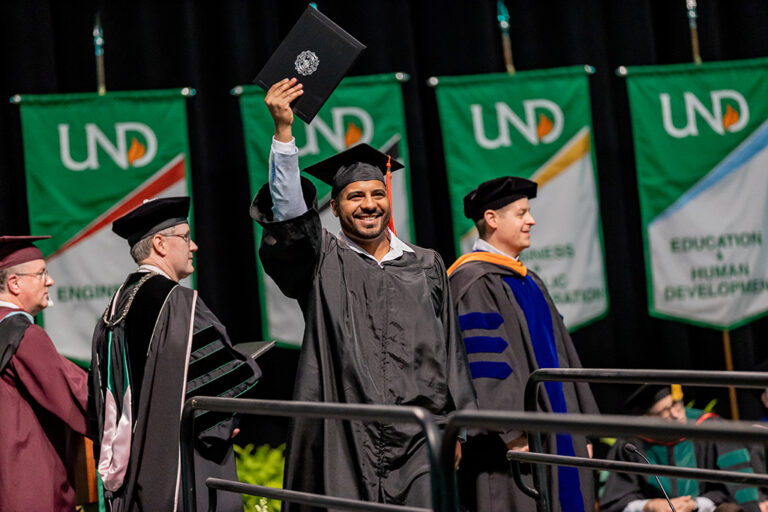 Graduate holding diploma