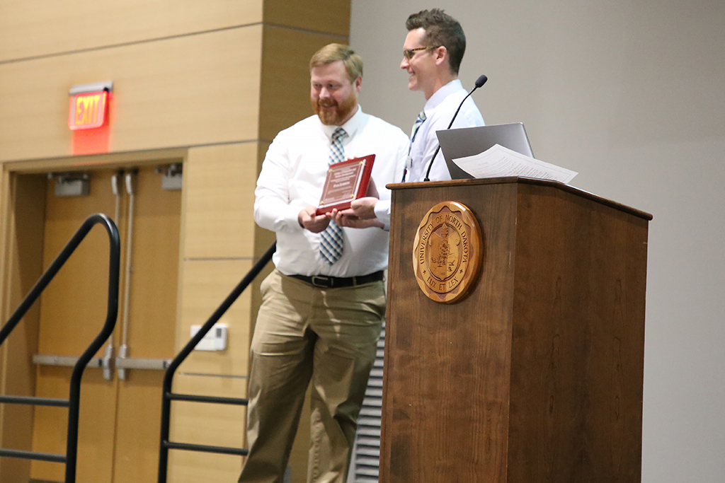man at podium receives award