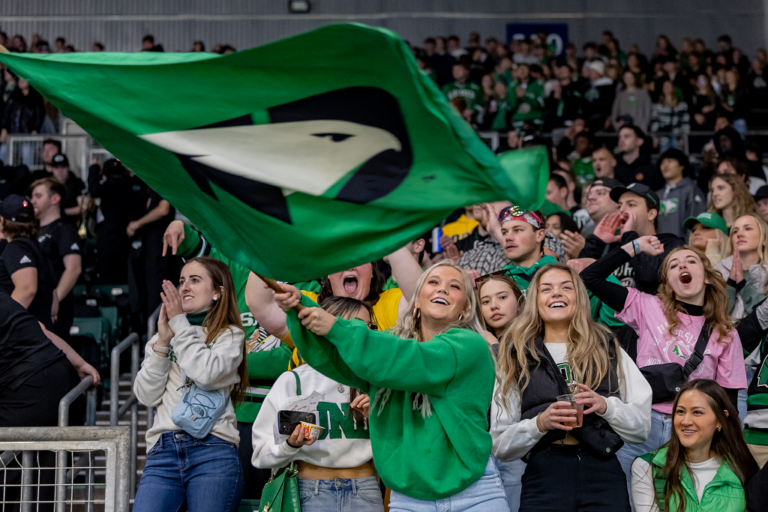 Student waving Fighting Hawk flag