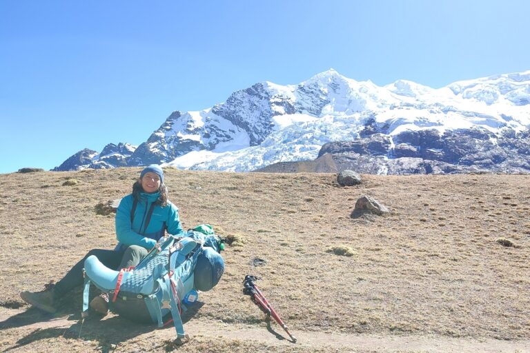 Anai Caparo Bellido with hiking pack and mountains in the background