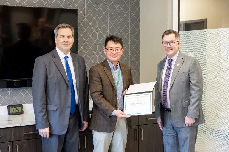 Chih Ming Tan holds certificate with Eric Link and Andrew Armacost