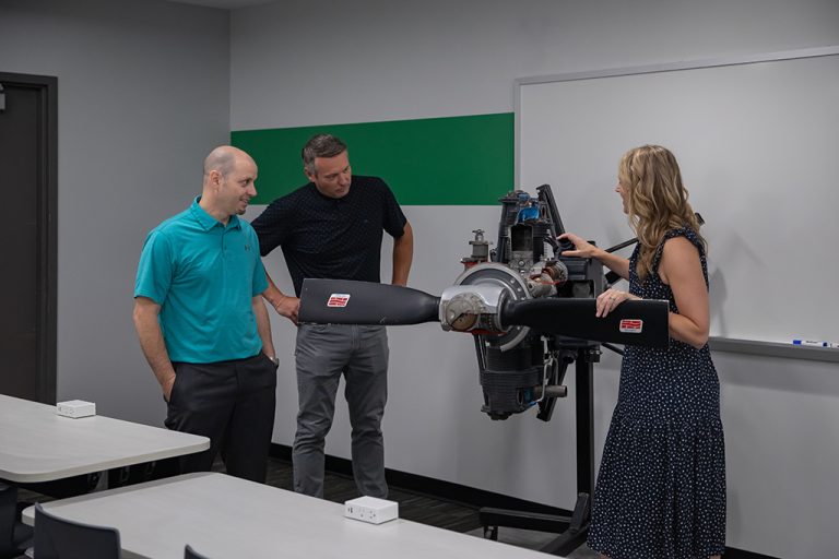 People in classroom with aircraft engine