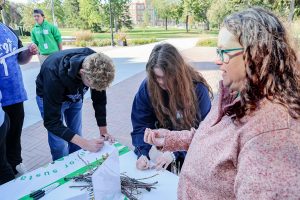 Students write on muslin for nest