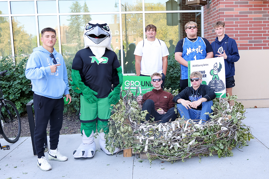 Students get photo with Fighting Hawk and nest