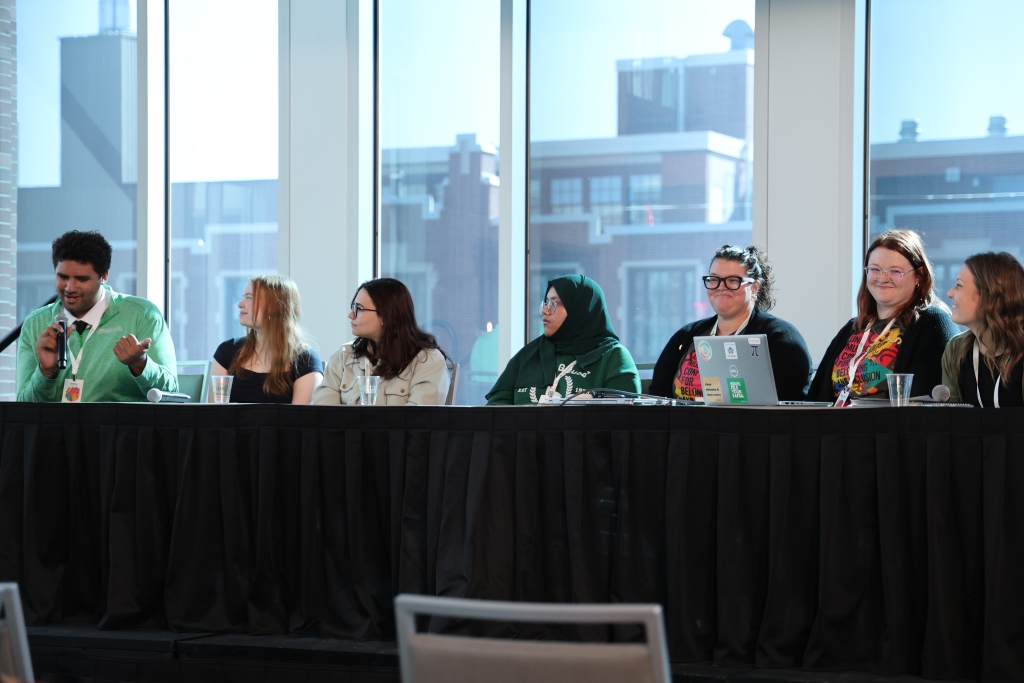 Panelists on stage. Panelists from left to right: Jaedon Hinds, Ellie Lynch, Raneem Kobeissy, Sumaiya, Stacey Barboa-Peterson, Shelby King and Dani Schindele. 