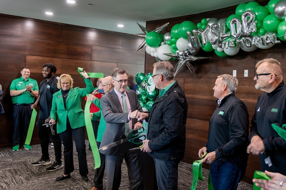 UND President Armacost fist-bumps with Steve Burian at the opening of UND Athletics' new offices