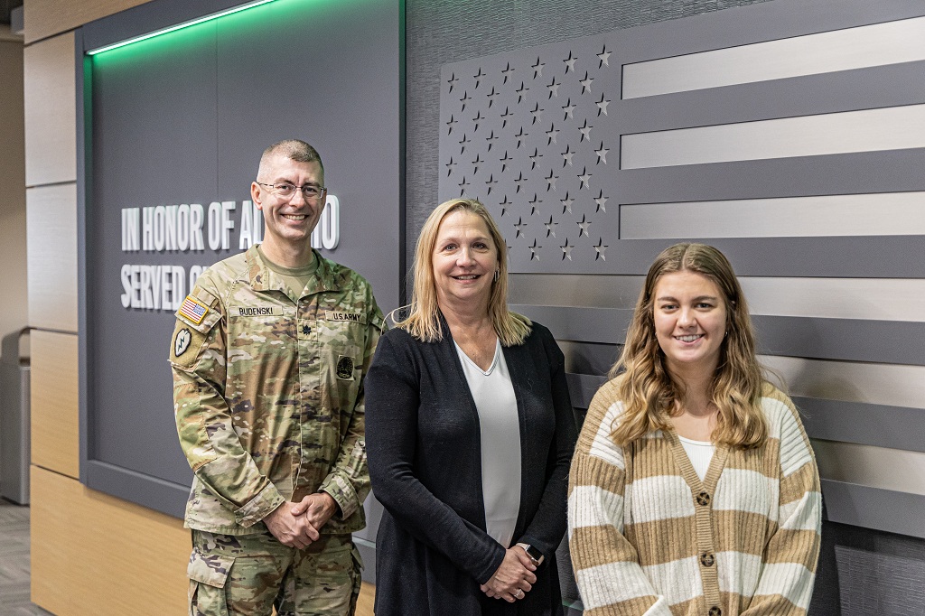 Lt. Col. Jared Budenski, Angie Carpenter and Maddie Lewis, the authors of today's UND LEADS "Affinity" letter, stand by the Veterans Honor Wall in the UND Memorial Union.