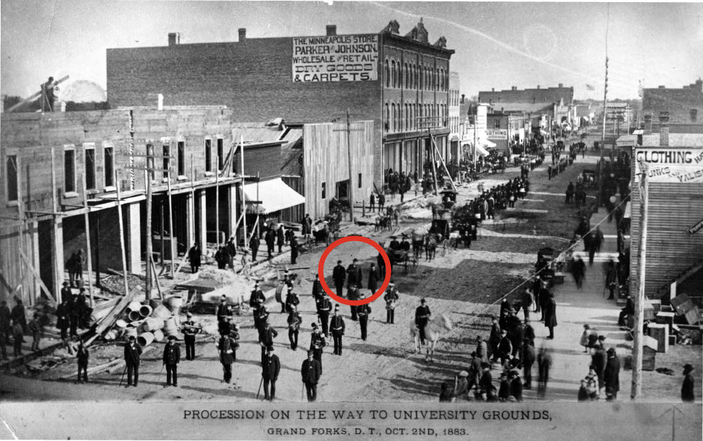 Photograph from 1883 shows procession through Grand Forks with red circle drawn around Nehemiah Ordway