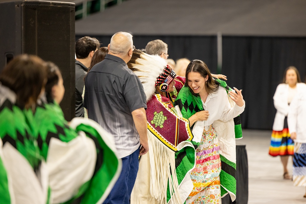 INMED graduate gets Star Quilt draped around her shoulders.