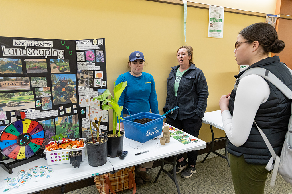 Emily Orr and Melissa Grafenauer talk to a guest at Earth Day