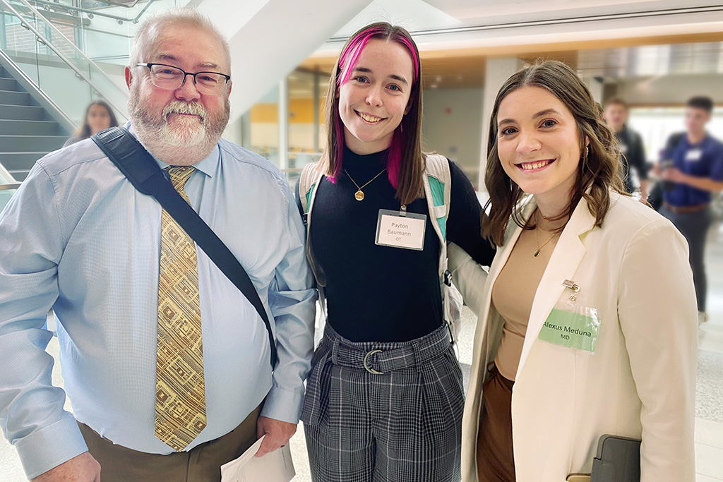 Dr. Eric Johnson stands with with occupational therapy student Payton Baumann and medical student Alexus Meduna at inaugural UND School of Medicine & Health Sciences Interprofessional Healthcare Day.