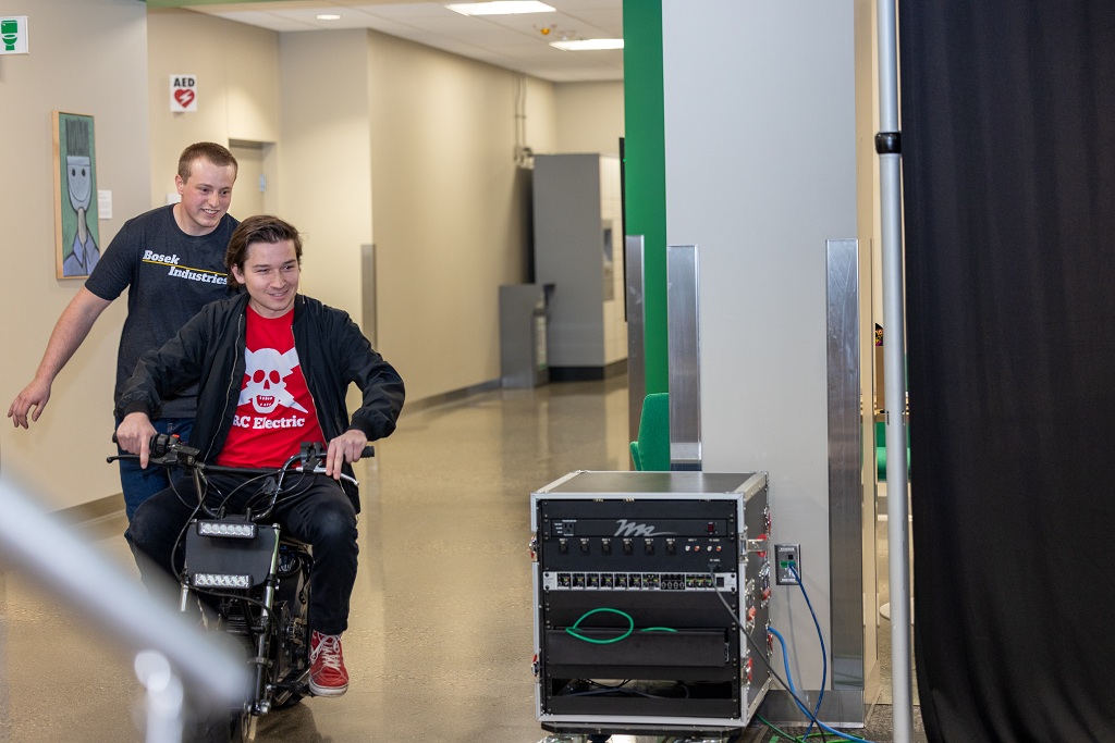 Spencer Milanowski rides his electric motorcycle through corridor