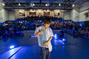 A young boy showcases his ribbon design on the runway.
