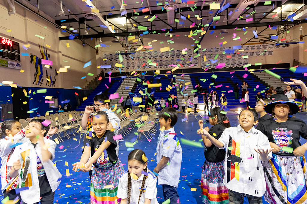 Young models smile as they try to catch pieces of colorful confetti raining down on them.