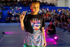 A young girl poses on the runway during the fashion show.