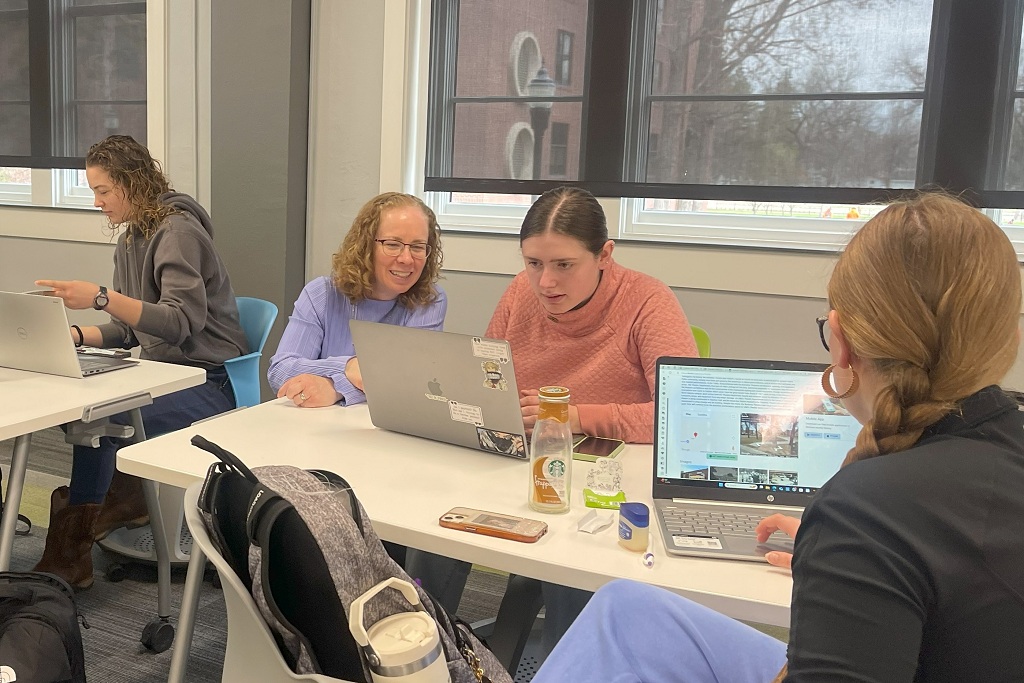 Cynthia Prescott helps a student in a class