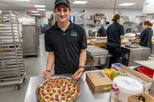Student Jacob Wright shows a finished tray of Berry Tarts.