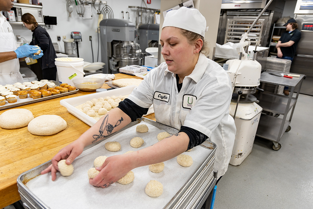 Bakery Manager Caylie Salge spaces out buns on a pan before popping it into the oven.