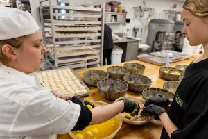 Bakery Manager Caylie Salge shares some Monkey Bread tips with a student worker.