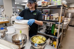 Ross Veselsky preps pickle bowls for the hamburger feast.