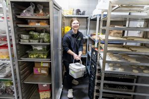 A UND student worker fetches ingredients from the cooler. 