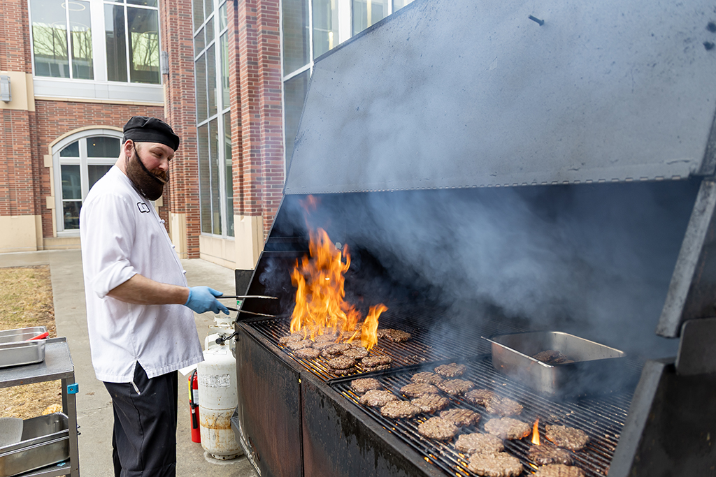 Mitch Vervalen fries hamburgers on the outdoor grill.