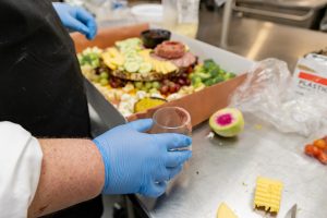 Catering Chef Micheal Longwell builds his salami rosette by folding thin slices over the open end of a small glass.