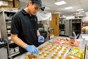 Student Jacob Wright adds berries to the tarts.