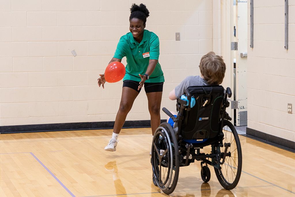counselor and child playing with balloon