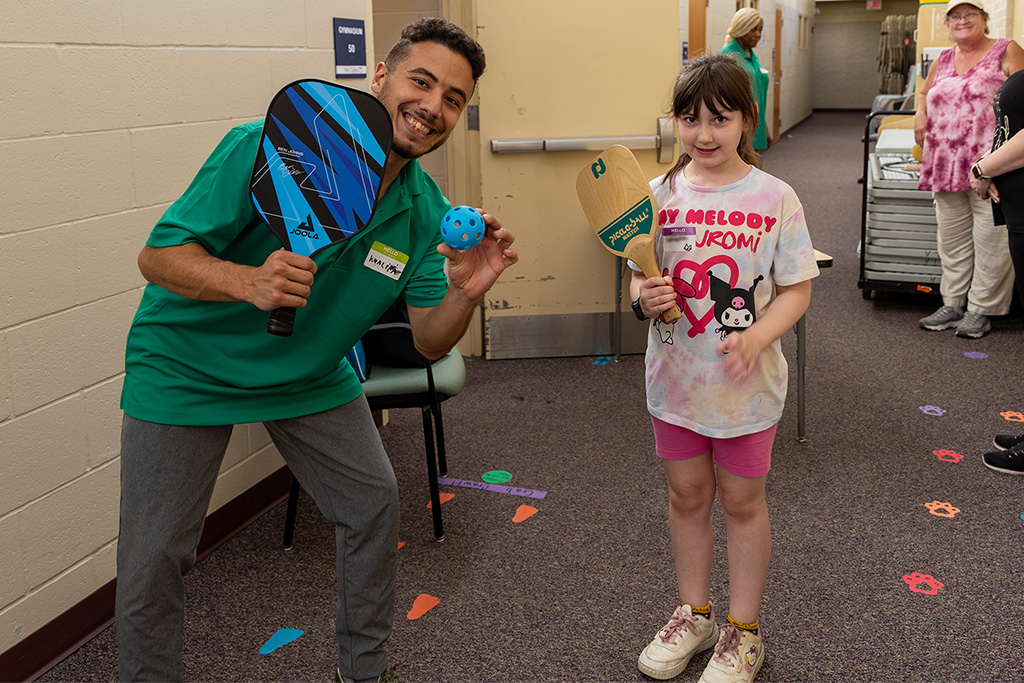 instructor and child with pickleball rackets