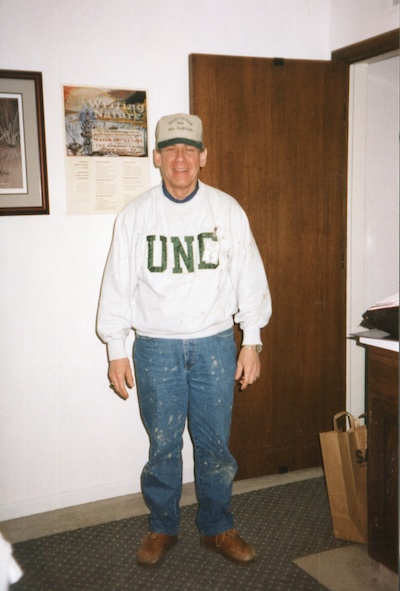 UND President Ken Baker in a UND sweatshirt and muddy jeans.