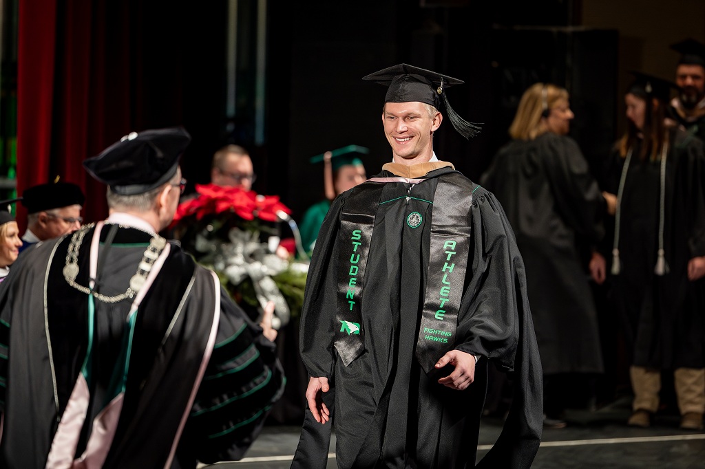 Jaden Norby crosses stage during Winter Commencement 2025,