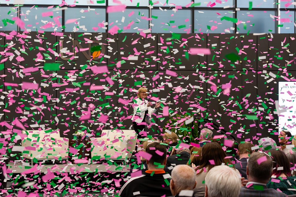 Confetti almost completely obscures view of DeAnna Carlson Zink, CEO of the UND Alumni Association & Foundation, who is delivering her State of the AA&F Address at the Gorecki Alumni Center on Jan. 29..