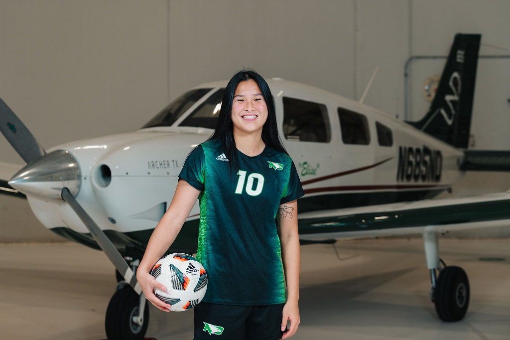 Irene Jirasevijinda stands by UND single-engine aircraft at Grand Forks International Airport. 