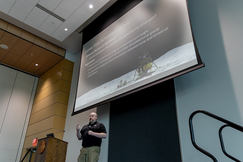 Professor giving talk on stage at conference