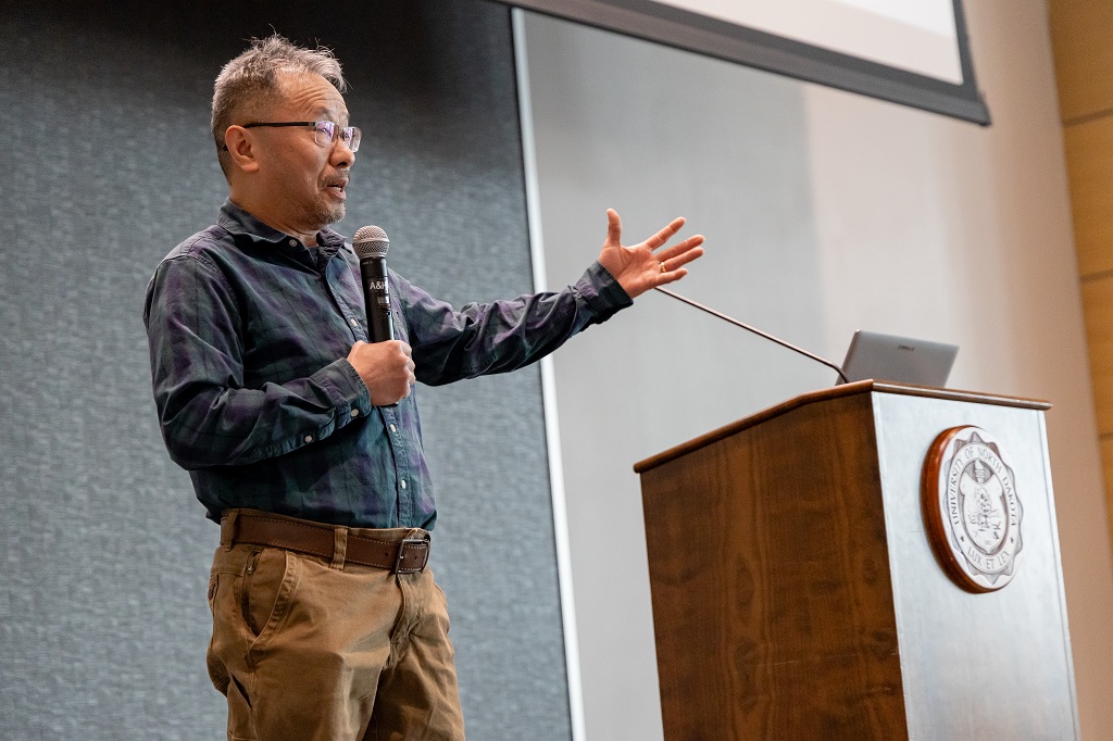 Professor giving talk behind podium that bears UND seal