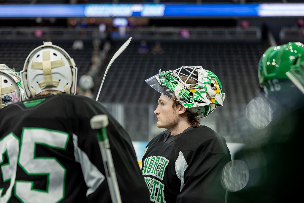UND hockey player with mask lifted, at practice on the T-Mobile Arena ice.