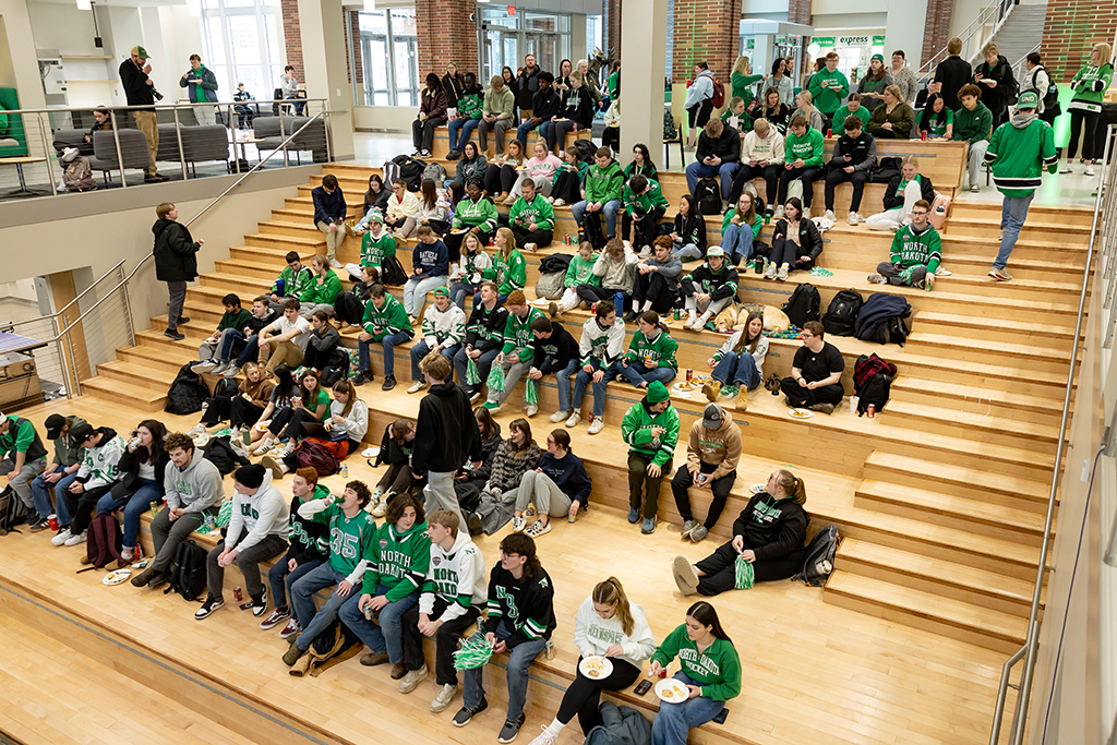 many students sit on a large, ampitheater-like staircase.