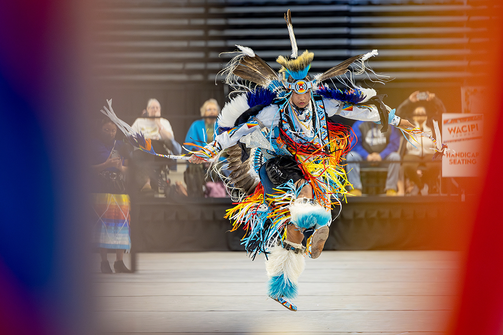 Person in full, colorful regalia dancing at Time Out Wacipi Powwow
