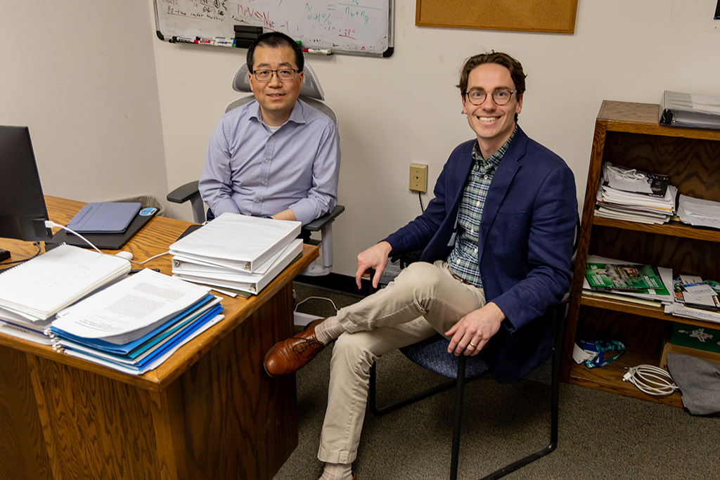 two men sitting behind a desk