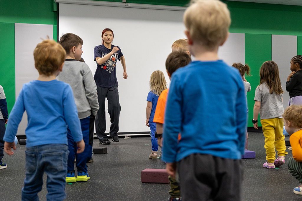 graduate student leading children in dance