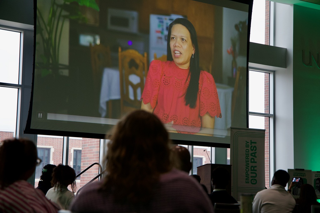 People watch as a woman speaks in a documentary about her life.
