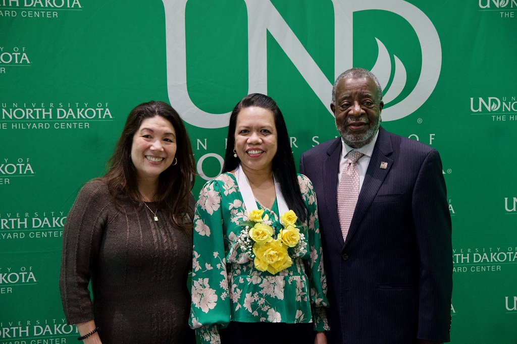 Four people stand in line at a UND event