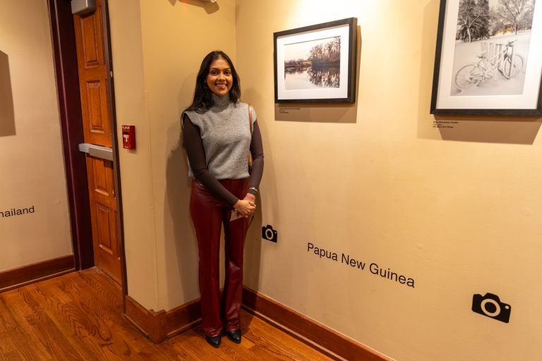 Yeshani Withana Pathirannehelage stands next to her photo