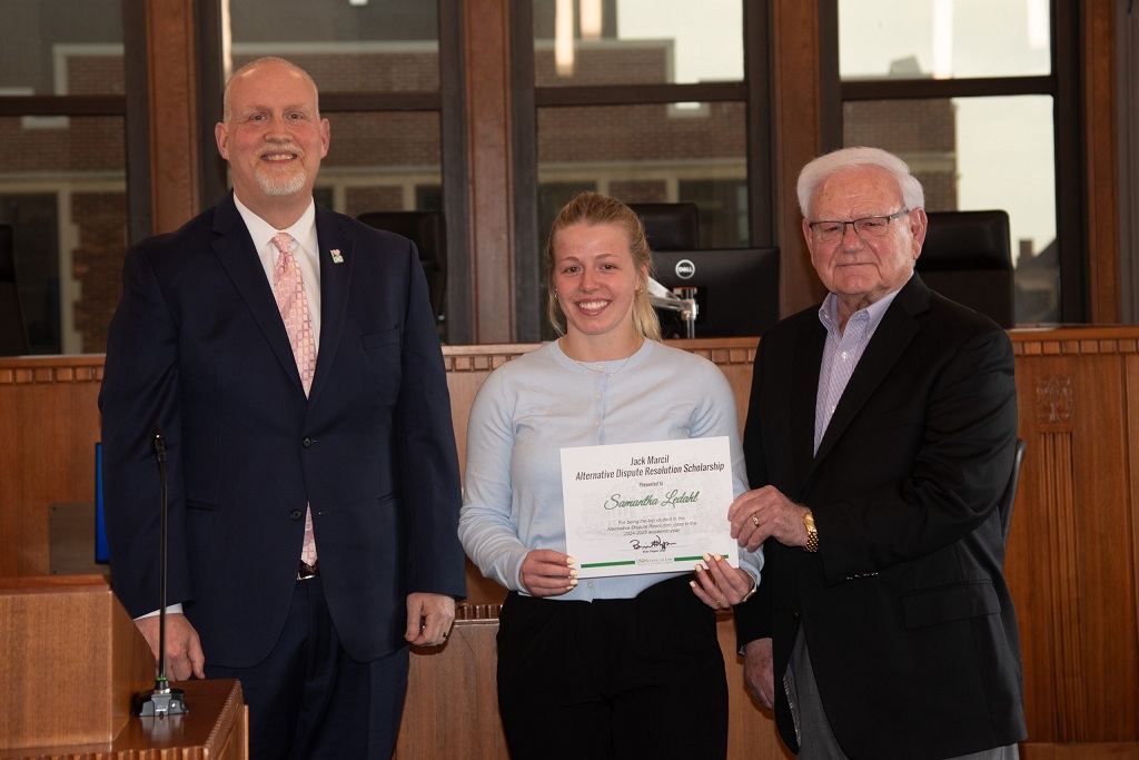 Three people stand at UND School of Law awards ceremonty