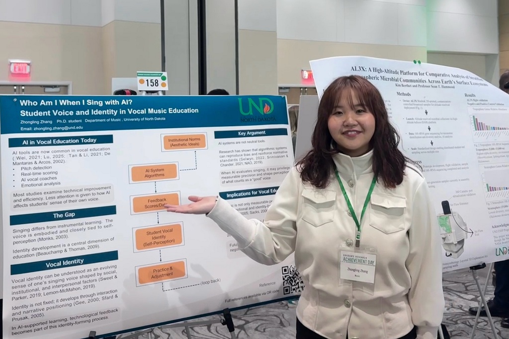Zhongling Zhang, a UND graduate student, stans by a poster board that describes her research