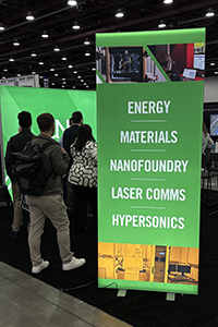 Poster at UND booth lists subjects of energy, materials, nanofoundry, laser comms and hypersonics.