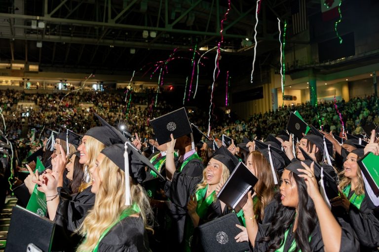 Graduates cheering at Commencement ceremony