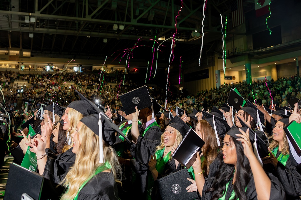 Graduates cheering at Commencement ceremony